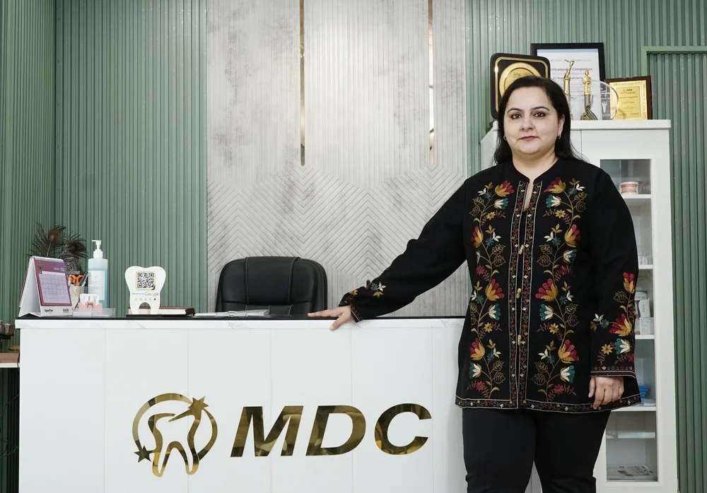 Dr. Supreet Kaur Sawhney standing at the reception desk of Marwaha Dental Clinic in Sector 39, Gurugram